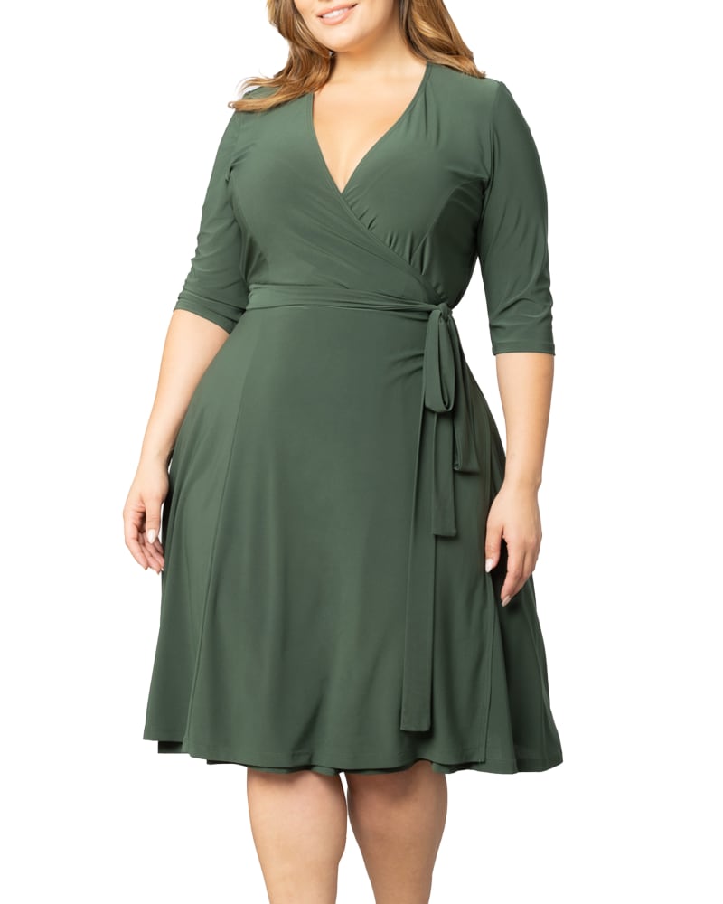 Front of a model wearing a size 0X Essential Wrap Dress in OLIVE GREEN by Kiyonna. | dia_product_style_image_id:353135